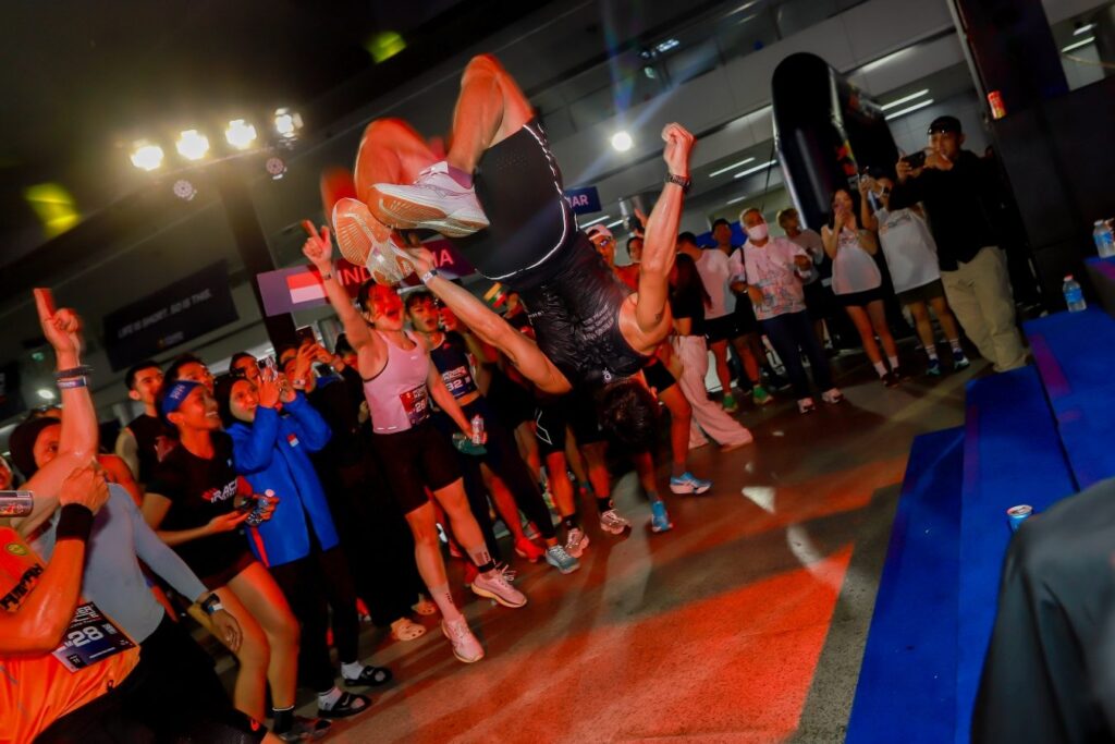 An athlete performs a backflip as the crowd cheers at the Red Bull Power Race International Final